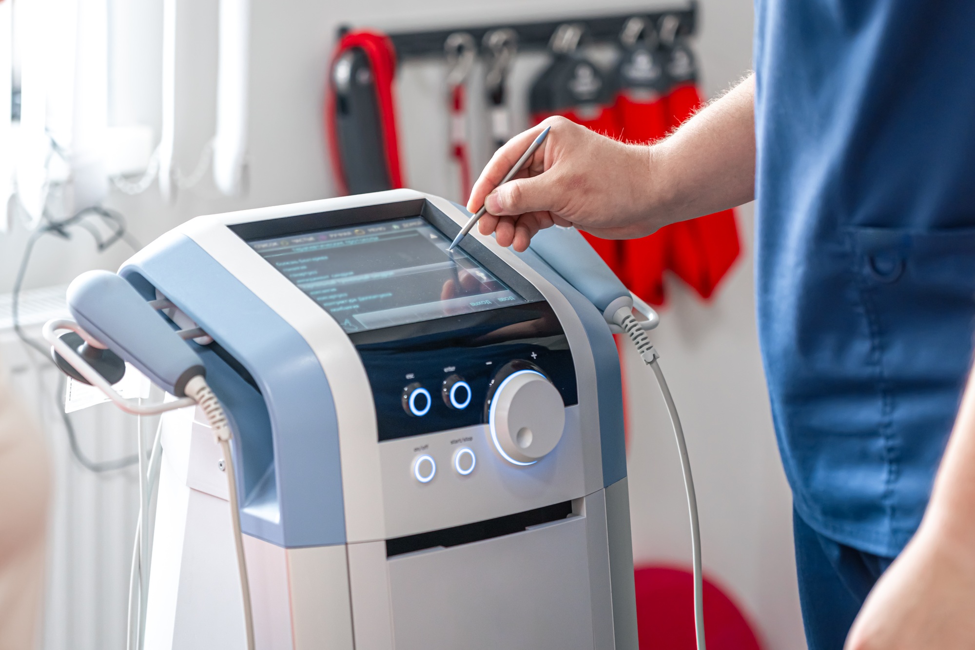 Physiotherapist doctor uses medical equipment for effective pain treatment.